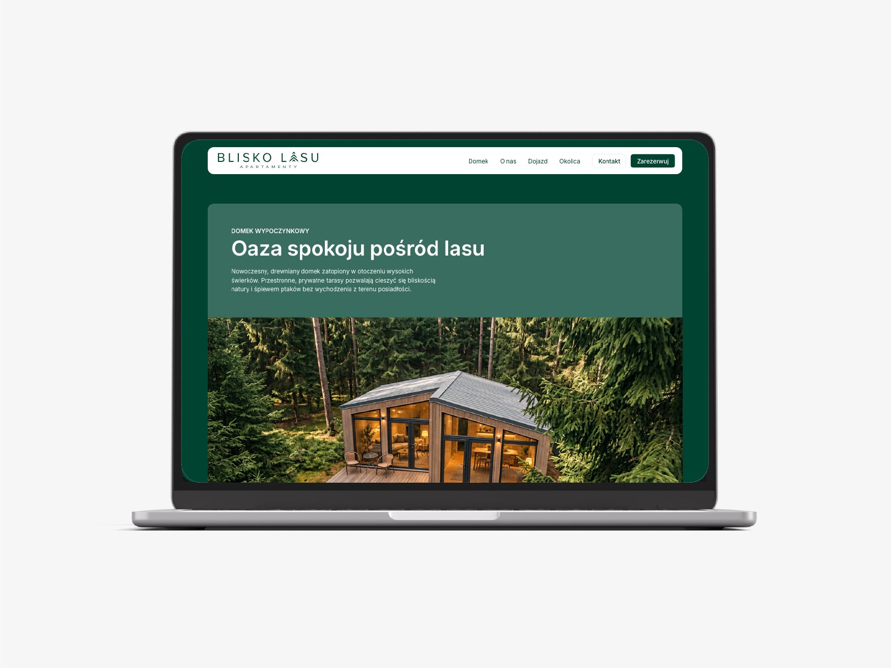 Laptop displaying a Polish vacation-rental website with a forest cabin photograph and green layout.