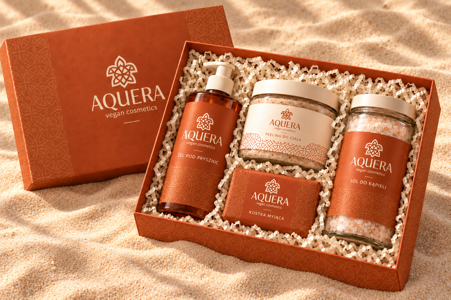 Open orange AQUERA vegan cosmetics gift box containing four labeled bath and body products.